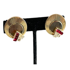 Pair of vintage Marcel Boucher gold‑tone disk clip‑on earrings with ruby‑red baguette rhinestones and clear rhinestone accents.