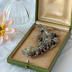 Vintage 1930s floral spray brooch with brown moonglow cabochons and green rhinestones in silver‑tone pot metal.