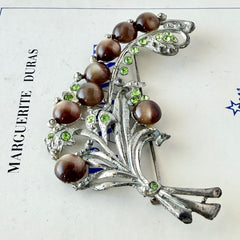 Vintage 1930s floral spray brooch with brown moonglow cabochons and green rhinestones in silver‑tone pot metal.