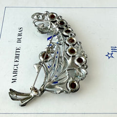 Vintage 1930s floral spray brooch with brown moonglow cabochons and green rhinestones in silver‑tone pot metal.