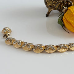 Vintage gold tone bracelet with textured links and pavé rhinestone floral accents