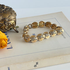 Vintage gold tone bracelet with textured links and pavé rhinestone floral accents