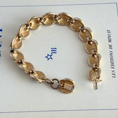 Vintage gold tone bracelet with textured links and pavé rhinestone floral accents