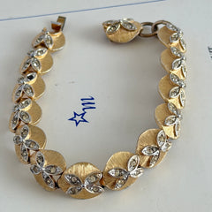 Vintage gold tone bracelet with textured links and pavé rhinestone floral accents