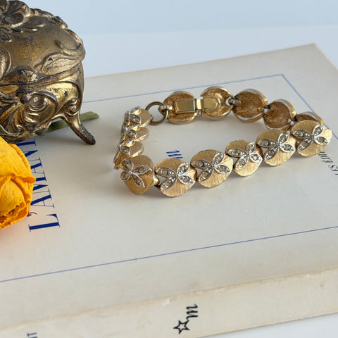 Vintage gold tone bracelet with textured links and pavé rhinestone floral accents