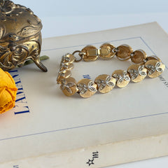 Vintage gold tone bracelet with textured links and pavé rhinestone floral accents