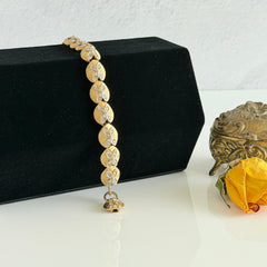 Vintage gold tone bracelet with textured links and pavé rhinestone floral accents