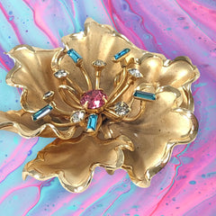 Vintage Bugbee & Niles brushed gold tone flower brooch with pink, aqua, and clear rhinestones, shown from multiple angles to highlight its dimensional petals and detailed construction.