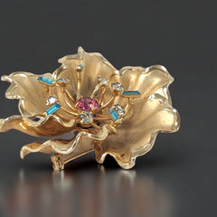 Vintage Bugbee & Niles brushed gold tone flower brooch with pink, aqua, and clear rhinestones, shown from multiple angles to highlight its dimensional petals and detailed construction.