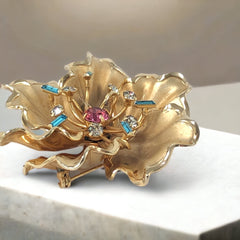Vintage Bugbee & Niles brushed gold tone flower brooch with pink, aqua, and clear rhinestones, shown from multiple angles to highlight its dimensional petals and detailed construction.