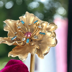 Vintage Bugbee & Niles brushed gold tone flower brooch with pink, aqua, and clear rhinestones, shown from multiple angles to highlight its dimensional petals and detailed construction.