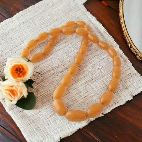 Vintage French Art Deco light butterscotch bakelite long necklace with polished oval beads and brass screw clasp.