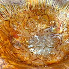 Vintage Imperial Glass marigold carnival bowl with Lustre Rose pattern, iridescent finish, scalloped edge, and three-footed base.