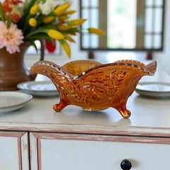 Vintage Imperial Glass marigold carnival bowl with Lustre Rose pattern, iridescent finish, scalloped edge, and three-footed base.