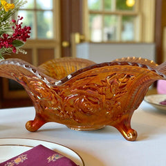 Vintage Imperial Glass marigold carnival bowl with Lustre Rose pattern, iridescent finish, scalloped edge, and three-footed base.
