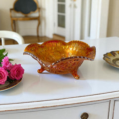 Vintage Imperial Glass marigold carnival bowl with Lustre Rose pattern, iridescent finish, scalloped edge, and three-footed base.