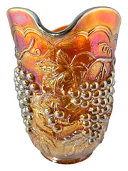 Vintage marigold Carnival Glass pitcher with iridescent grape and leaf pattern, likely Imperial Glass, featuring warm amber, rose, and copper tones; approx. 8¼" tall, in very good condition with minor chips noted on base and rim, ideal for fall decor or vintage display.