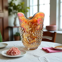 Vintage marigold Carnival Glass pitcher with iridescent grape and leaf pattern, scalloped rim, and curved handle; warm amber tones ideal for fall decor or collector display.