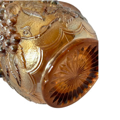 Vintage marigold Carnival Glass pitcher with iridescent grape and leaf pattern, scalloped rim, and curved handle; warm amber tones ideal for fall decor or collector display.