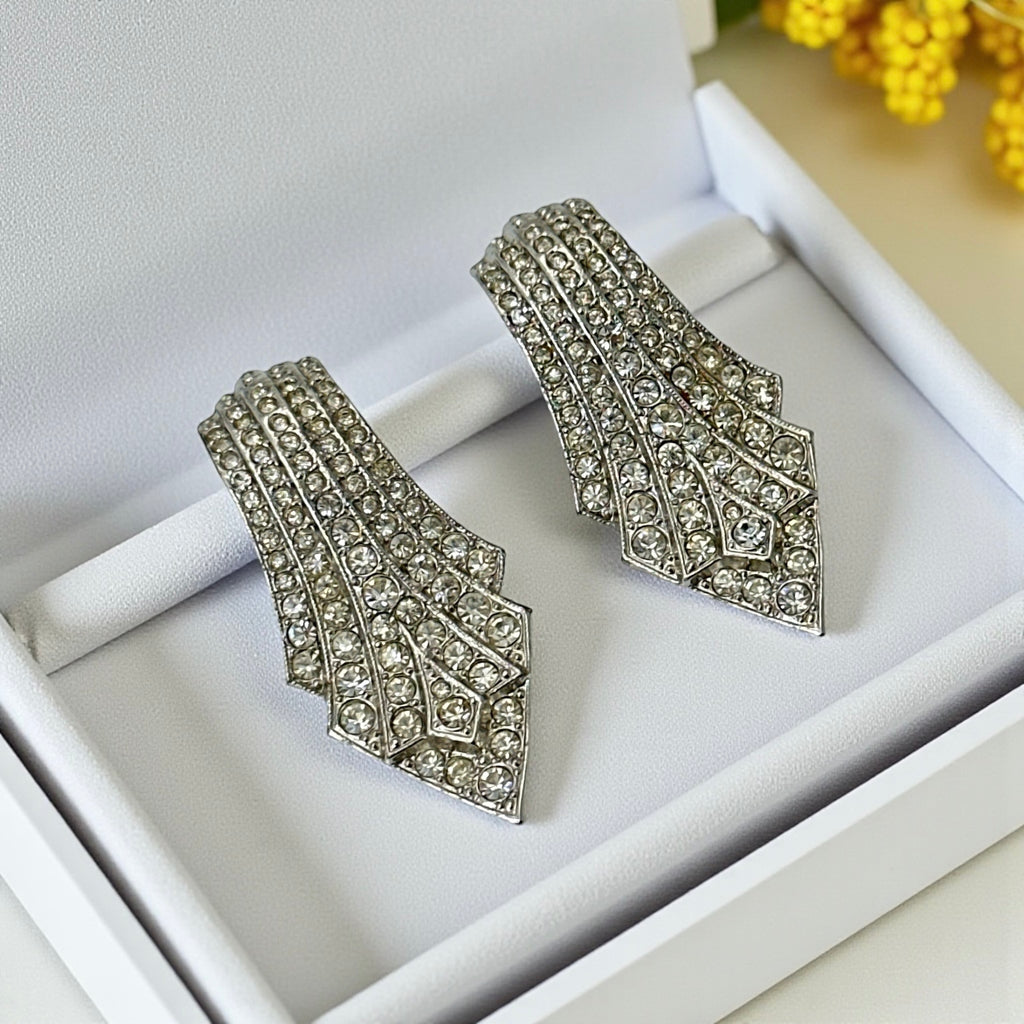 Vintage Carolee clip-on earrings with silver-tone Art Deco design and clear pave rhinestones; signed and in very good condition, circa 1980s.