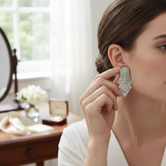 Vintage Carolee clip-on earrings with silver-tone Art Deco design and clear pave rhinestones; signed and in very good condition, circa 1980s.
