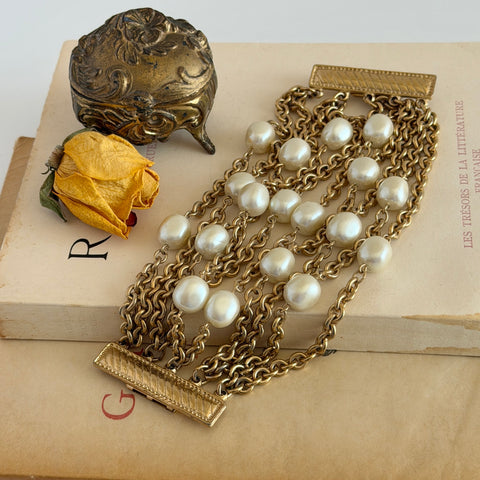 Vintage Carolee bracelet with ten strands of faux pearls and gold‑tone chains and a sculptural bar clasp.