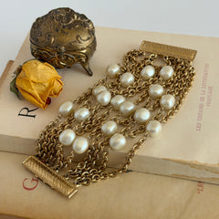 Vintage Carolee bracelet with ten strands of faux pearls and gold‑tone chains and a sculptural bar clasp.