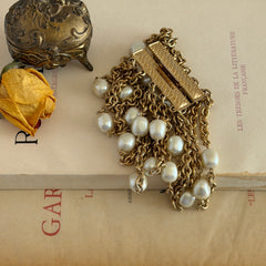 Vintage Carolee bracelet with ten strands of faux pearls and gold‑tone chains and a sculptural bar clasp.