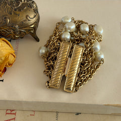 Vintage Carolee bracelet with ten strands of faux pearls and gold‑tone chains and a sculptural bar clasp.