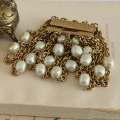 Vintage Carolee bracelet with ten strands of faux pearls and gold‑tone chains and a sculptural bar clasp.