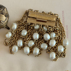 Vintage Carolee bracelet with ten strands of faux pearls and gold‑tone chains and a sculptural bar clasp.