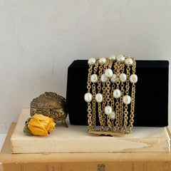 Vintage Carolee bracelet with ten strands of faux pearls and gold‑tone chains and a sculptural bar clasp.