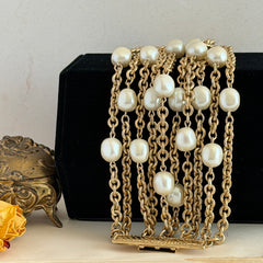 Vintage Carolee bracelet with ten strands of faux pearls and gold‑tone chains and a sculptural bar clasp.