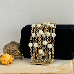 Vintage Carolee bracelet with ten strands of faux pearls and gold‑tone chains and a sculptural bar clasp.
