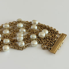 Vintage Carolee bracelet with ten strands of faux pearls and gold‑tone chains and a sculptural bar clasp.