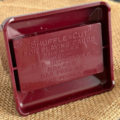 Vintage maroon Carvanite Shuffle Cut card shuffler by Lea Industries, shown on burlap fabric.
