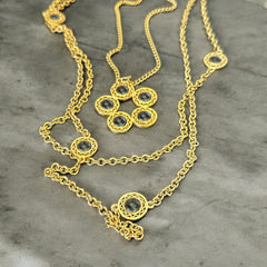 Vintage Celebrity gold‑tone necklace with gray glass chicklet elements, featuring a five‑round floral pendant and multiple convertible strands.