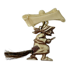 Vintage French brooch depicting a witch flying on a broom, crafted from celluloid with horsehair bristles; she wears a headscarf and holds a wand, mid-century design from the 1950s–60s, approx. 1¾" x 1½", in very good condition with secure pin back and folk-inspired detailing.