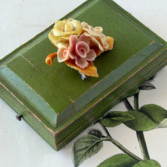 Vintage 1950s celluloid floral brooch with pink, yellow, and cream roses on a single brown leaf, shown from multiple angles.