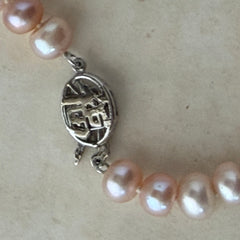 Vintage Chinese light pink freshwater pearl necklace with silver‑tone clasp engraved with Chinese characters.