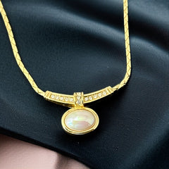 Vintage 1970s Christian Dior necklace featuring a luminous faux pearl pendant accented with pave rhinestones, suspended from a gold plated cobra chain with adjustable spring ring clasp and signed ChrDior © hang tag.