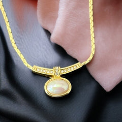 Vintage 1970s Christian Dior necklace featuring a luminous faux pearl pendant accented with pave rhinestones, suspended from a gold plated cobra chain with adjustable spring ring clasp and signed ChrDior © hang tag.