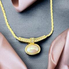 Vintage 1970s Christian Dior necklace featuring a luminous faux pearl pendant accented with pave rhinestones, suspended from a gold plated cobra chain with adjustable spring ring clasp and signed ChrDior © hang tag.