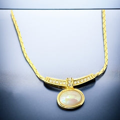 Vintage 1970s Christian Dior necklace featuring a luminous faux pearl pendant accented with pave rhinestones, suspended from a gold plated cobra chain with adjustable spring ring clasp and signed ChrDior © hang tag.