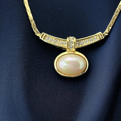 Vintage 1970s Christian Dior necklace featuring a luminous faux pearl pendant accented with pave rhinestones, suspended from a gold plated cobra chain with adjustable spring ring clasp and signed ChrDior © hang tag.