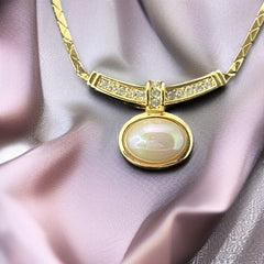 Vintage 1970s Christian Dior necklace featuring a luminous faux pearl pendant accented with pave rhinestones, suspended from a gold plated cobra chain with adjustable spring ring clasp and signed ChrDior © hang tag.