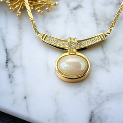Vintage 1970s Christian Dior necklace featuring a luminous faux pearl pendant accented with pave rhinestones, suspended from a gold plated cobra chain with adjustable spring ring clasp and signed ChrDior © hang tag.