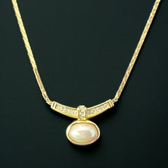 Vintage 1970s Christian Dior necklace featuring a luminous faux pearl pendant accented with pave rhinestones, suspended from a gold plated cobra chain with adjustable spring ring clasp and signed ChrDior © hang tag.