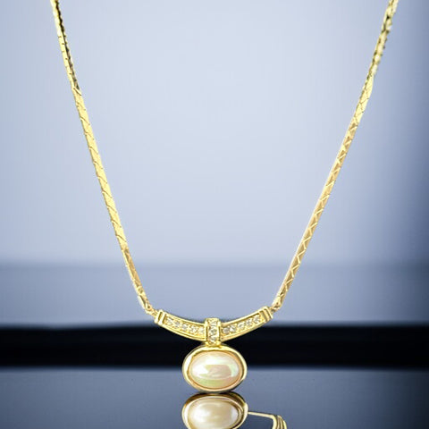 Vintage 1970s Christian Dior necklace featuring a luminous faux pearl pendant accented with pave rhinestones, suspended from a gold plated cobra chain with adjustable spring ring clasp and signed ChrDior © hang tag.