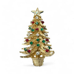 Vintage 1980s gold tone Christmas tree brooch with red, green, and clear rhinestones, featuring a star topper and woven basket base; shown from multiple angles to highlight dimensional detail, condition, and clasp.
